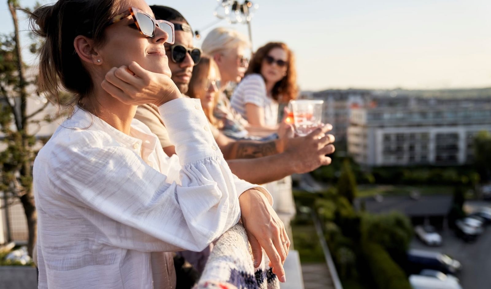 Group of people standing on a balcony in the sunshine e1729199363583